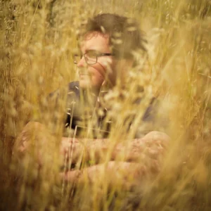 Home - Dakota Dean sitting in tall grass